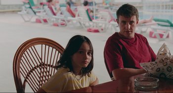 Movie still from “Aftersun” (2022), directed by Charlotte Wells – A man and a little girl sitting at a table; Medium shot, Over the shoulder angle