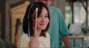 Movie still from “Aftersun” (2022), directed by Charlotte Wells – A young girl holding a toothbrush in her hand; Close Up shot, Over the shoulder angle