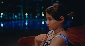 Movie still from “Aftersun” (2022), directed by Charlotte Wells – A young girl is holding a pair of glasses; Close Up shot, High angle