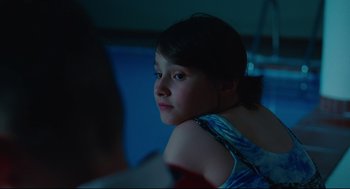 Movie still from “Aftersun” (2022), directed by Charlotte Wells – A young girl sitting in front of a mirror; Close Up shot, Over the shoulder angle