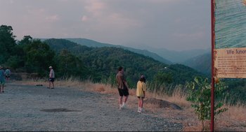 Movie still from “Aftersun” (2022), directed by Charlotte Wells – A man and a woman walking on a dirt road; Extreme Wide shot, High angle
