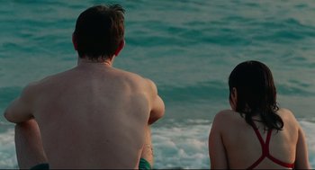 Movie still from “Aftersun” (2022), directed by Charlotte Wells – A man and a woman standing in the ocean; Medium shot, High angle