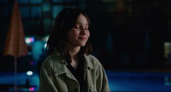 Movie still from “Aftersun” (2022), directed by Charlotte Wells – A young girl with her eyes closed and her eyes closed; Close Up shot, Over the shoulder angle