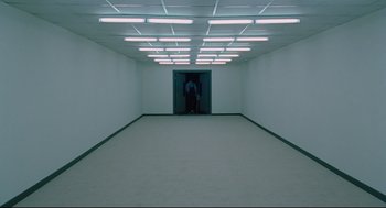 Movie still from “Aftersun” (2022), directed by Charlotte Wells – An empty room with a person standing in it; Extreme Wide shot, High angle