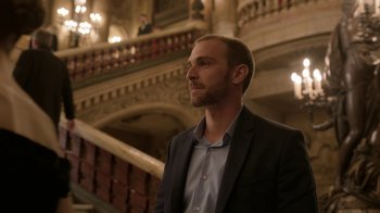 Movie still from “Emily in Paris” (2020), created by Darren Star – A man standing in front of a staircase in a building; Medium shot, Low angle