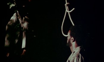 Movie still from “Ganja & Hess” (1973), directed by Bill Gunn – A man standing under a noose hanging from the ceiling; Medium shot, Low angle