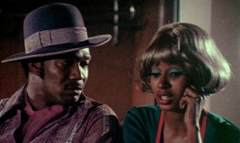 Movie still from “Ganja & Hess” (1973), directed by Bill Gunn – A man and a woman talking on a cell phone; Close Up shot, Low angle