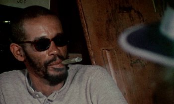Movie still from “Ganja & Hess” (1973), directed by Bill Gunn – A person smoking a cigarette; Close Up shot, Low angle