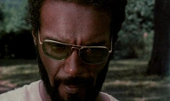 Movie still from “Ganja & Hess” (1973), directed by Bill Gunn – A person wearing sunglasses; Close Up shot, Low angle