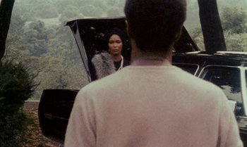 Movie still from “Ganja & Hess” (1973), directed by Bill Gunn – A man and a woman are looking into a car mirror; Medium shot, Over the shoulder angle