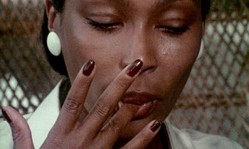 Movie still from “Ganja & Hess” (1973), directed by Bill Gunn – A person smoking a cigarette; Extreme Close Up shot, Low angle