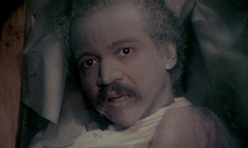 Movie still from “Ganja & Hess” (1973), directed by Bill Gunn – An old man with a beard and mustache is laying in a bed; Close Up shot, High angle
