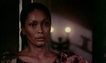 Movie still from “Ganja & Hess” (1973), directed by Bill Gunn – A person wearing a dress; Close Up shot, Over the shoulder angle