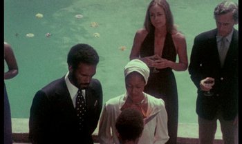 Movie still from “Ganja & Hess” (1973), directed by Bill Gunn – A group of people standing next to each other near a pool; Medium shot, High angle