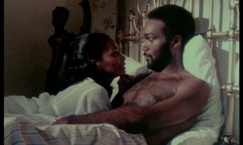 Movie still from “Ganja & Hess” (1973), directed by Bill Gunn – A man and a woman in a bed together; Medium shot, Low angle
