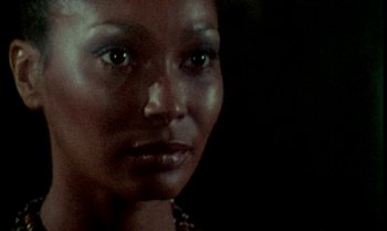 Movie still from “Ganja & Hess” (1973), directed by Bill Gunn – A woman's face in the dark; Close Up shot, Low angle