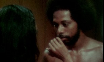 Movie still from “Ganja & Hess” (1973), directed by Bill Gunn – A man with long hair is looking at himself in the mirror; Close Up shot, Over the shoulder angle