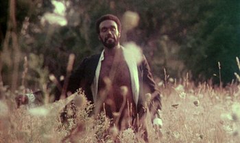 Movie still from “Ganja & Hess” (1973), directed by Bill Gunn – A man in a field with a beard; Medium shot, Low angle