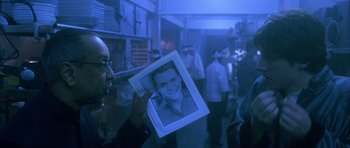 Movie still from “Garden State” (2004), directed by Zach Braff – A person holding a picture of a man in a blue room; Close Up shot, Over the shoulder angle