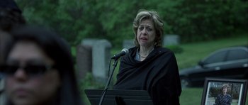 Movie still from “Garden State” (2004), directed by Zach Braff – A woman in a black shirt is speaking at a microphone; Close Up shot, Over the shoulder angle