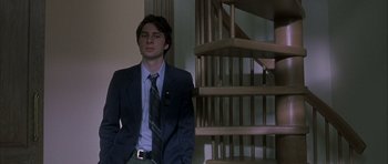 Movie still from “Garden State” (2004), directed by Zach Braff – A man in a suit standing in front of a staircase; Medium shot, Low angle