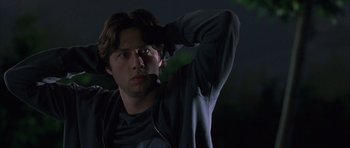 Movie still from “Garden State” (2004), directed by Zach Braff – A young man is standing in the dark with his hand up to his head; Close Up shot, Low angle
