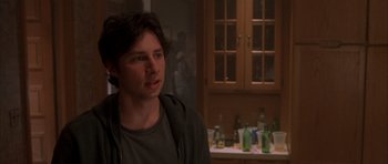 Movie still from “Garden State” (2004), directed by Zach Braff – A young man is standing in front of a counter; Medium shot, Over the shoulder angle