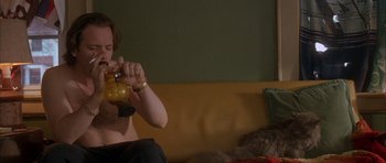 Movie still from “Garden State” (2004), directed by Zach Braff – A woman sitting on a bed holding a bottle; Medium shot, High angle