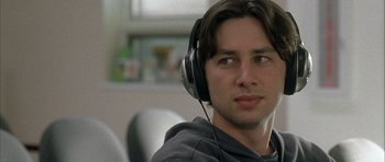 Movie still from “Garden State” (2004), directed by Zach Braff – A young man wearing headphones while sitting in a chair; Close Up shot, Low angle
