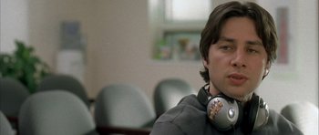 Movie still from “Garden State” (2004), directed by Zach Braff – A man with headphones sitting in front of a wall; Close Up shot, Over the shoulder angle