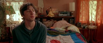 Movie still from “Garden State” (2004), directed by Zach Braff – A man sitting on top of a bed in a bedroom; Medium shot, Over the shoulder angle