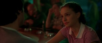 Movie still from “Garden State” (2004), directed by Zach Braff – A girl sitting at a table in front of other people; Close Up shot, Over the shoulder angle