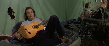 Movie still from “Garden State” (2004), directed by Zach Braff – A man sitting on the ground with a guitar; Medium shot, High angle