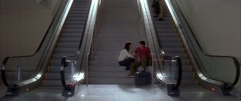 Movie still from “Garden State” (2004), directed by Zach Braff – A man and a woman sitting on the steps of an escalator; Wide shot, High angle