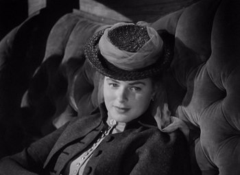 Movie still from “Gaslight” (1944), directed by George Cukor – A woman wearing a hat sitting on a couch; Close Up shot, High angle