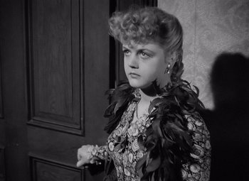 Movie still from “Gaslight” (1944), directed by George Cukor – A woman in a dress with feathers around her neck; Close Up shot, High angle