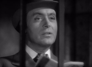 Movie still from “Gaslight” (1944), directed by George Cukor – A black and white photo of a man in a suit and hat; Close Up shot, Low angle