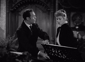 Movie still from “Gaslight” (1944), directed by George Cukor – A man and a woman standing next to each other in front of a bench; Medium shot, High angle