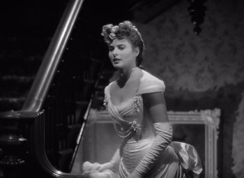 Movie still from “Gaslight” (1944), directed by George Cukor – A black and white photo of a woman in a dress; Medium shot, Low angle