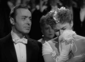 Movie still from “Gaslight” (1944), directed by George Cukor – A man and a woman in formal wear looking at each other; Close Up shot, Over the shoulder angle