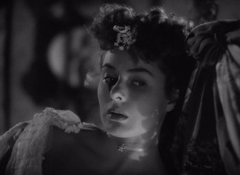 Movie still from “Gaslight” (1944), directed by George Cukor – A black - and - white photo of a woman with a flower in her hair; Close Up shot, Over the shoulder angle