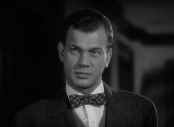 Movie still from “Gaslight” (1944), directed by George Cukor – A black and white photo of a man wearing a suit and bow tie; Close Up shot, Low angle