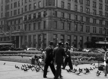 Movie still from “Gentleman's Agreement” (1947), directed by Elia Kazan – A black and white photo of a group of men walking down a street; Extreme Wide shot, High angle