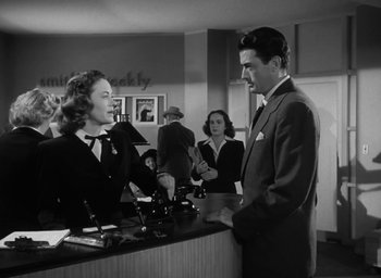 Movie still from “Gentleman's Agreement” (1947), directed by Elia Kazan – A man and a woman standing in front of a counter; Medium shot, Low angle