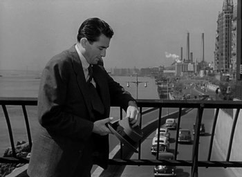 Movie still from “Gentleman's Agreement” (1947), directed by Elia Kazan – A black and white photo of a man in a suit and tie; Medium shot, Over the shoulder angle