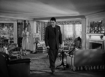 Movie still from “Gentleman's Agreement” (1947), directed by Elia Kazan – A man in a suit walking in a living room; Wide shot, High angle