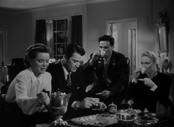 Movie still from “Gentleman's Agreement” (1947), directed by Elia Kazan – A black and white photo of a group of people sitting at a table; Medium shot, High angle