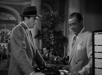 Movie still from “Gentleman's Agreement” (1947), directed by Elia Kazan – Two men in suits and hats stand in front of a tree; Medium shot, Low angle