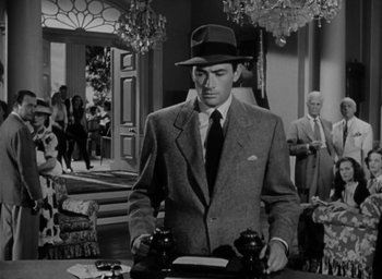 Movie still from “Gentleman's Agreement” (1947), directed by Elia Kazan – A black and white photo of a man in a suit and hat; Medium shot, Low angle