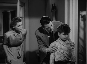 Movie still from “Gentleman's Agreement” (1947), directed by Elia Kazan – An old photo of a man and a woman looking at a young boy; Medium shot, High angle